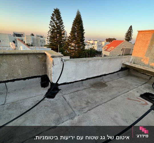 איטום גג עם חומר שחור לאורך הפינות והחיבורים